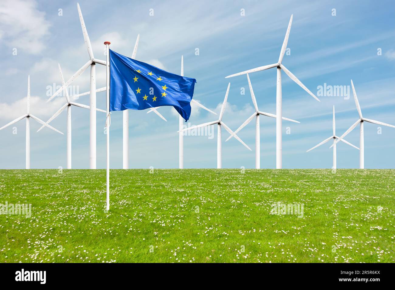 Offizielle Flagge der Europäischen Union auf Gras vor einem großen Windpark mit Windturbinen Stockfoto