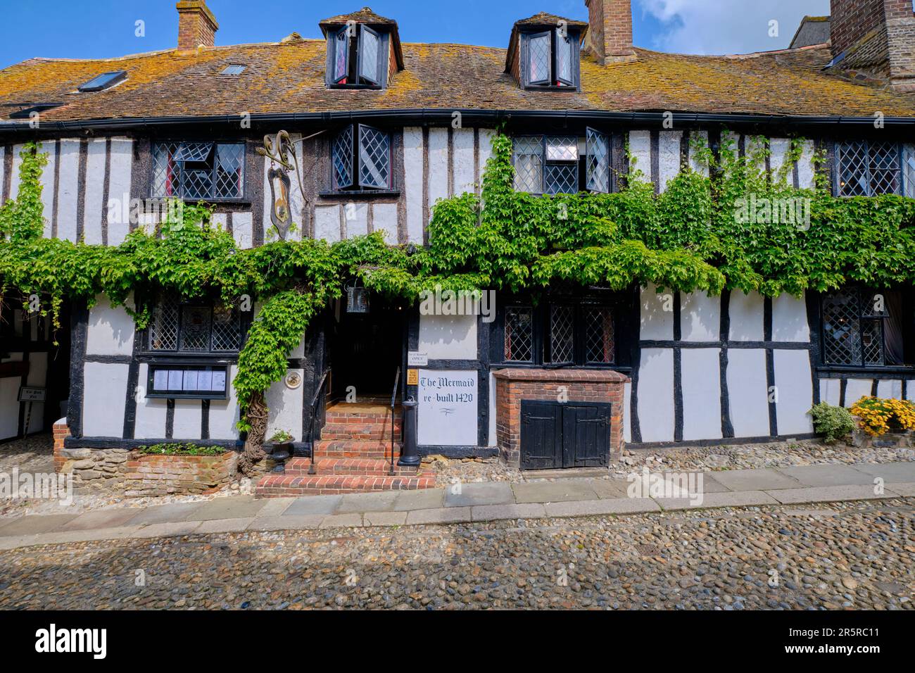 Rye, East Sussex, England, Europa - 18. Mai 2023: The Mermaid - antikes Hotel in einer kopfsteingepflasterten Straße. Eine kleine englische mittelalterliche Küstenstadt auf einer Sonne Stockfoto