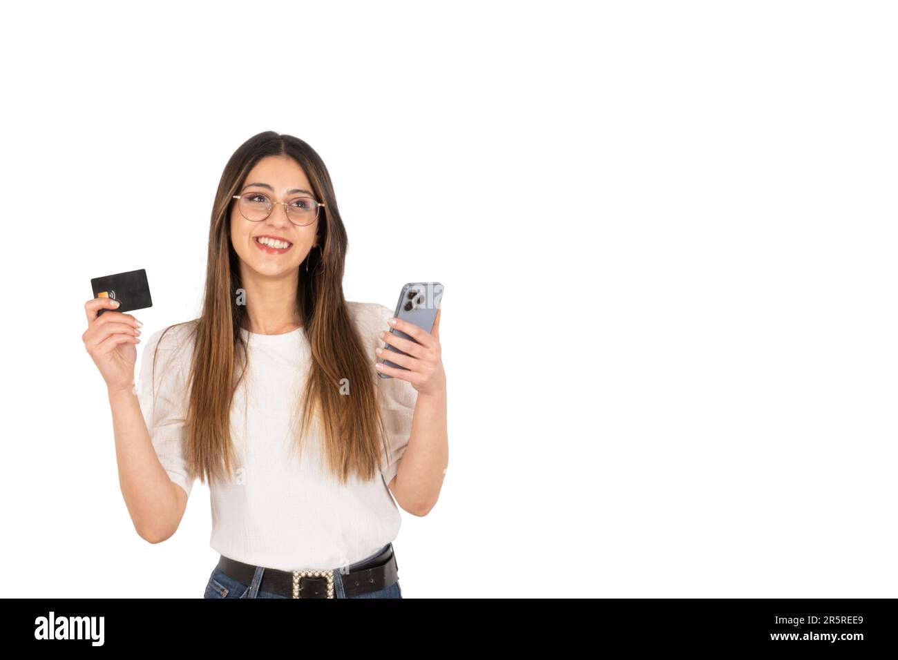 Online-Zahlungskonzept für junge Mädchen. Junge Brünette Frau mit schwarzer Plastikkarte und modernem Handy an den Händen. Stockfoto