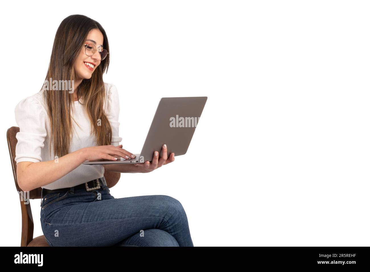 Lächelnde glückliche kaukasierin, die einen Laptop hält und arbeitet. Seitenansichtsporträt einer kaukasischen Geschäftsfrau mit Notizbuch. Lifestyle-Konzeptidee. Stockfoto