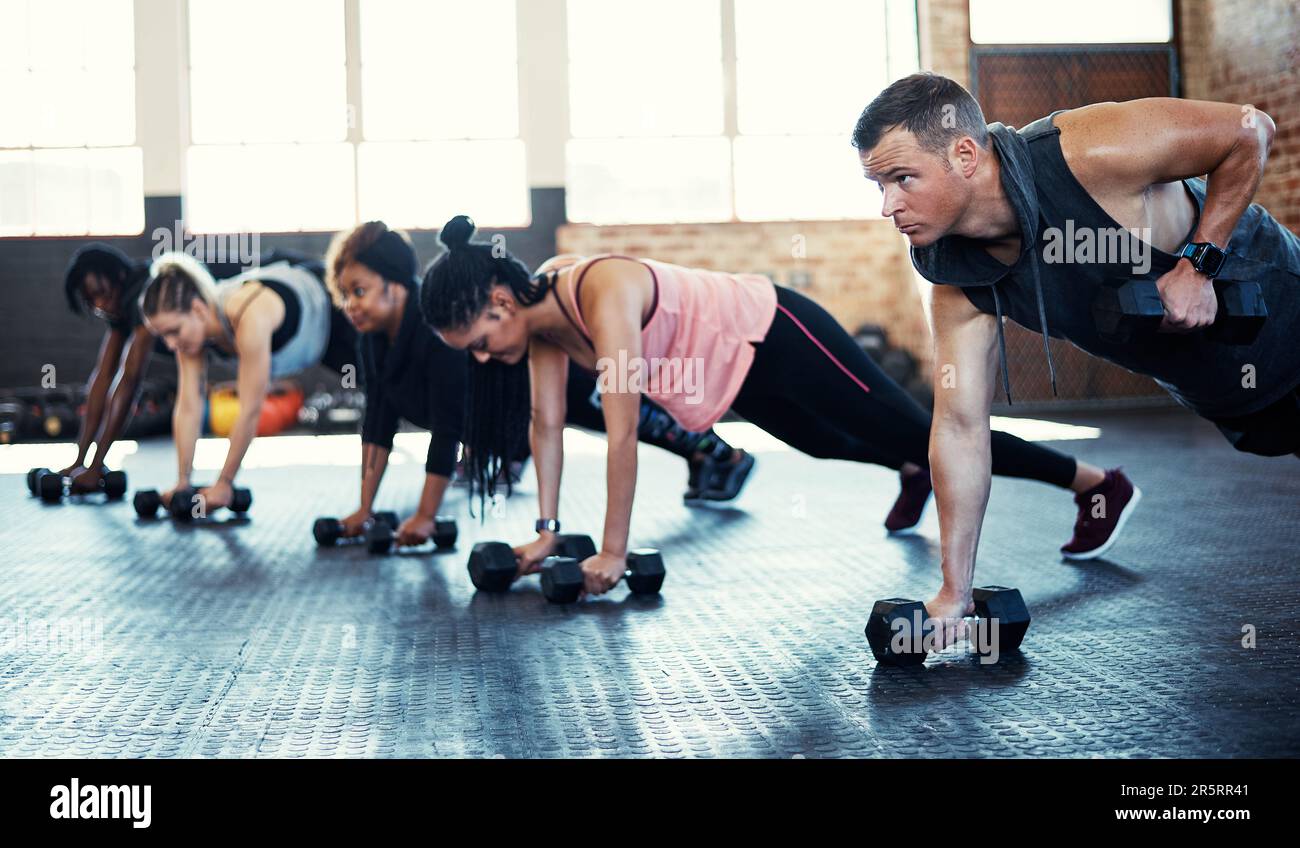 Härter drücken und fitter werden. Eine Fitnessgruppe, die beim Training im Fitnessstudio Kurzhanteln verwendet. Stockfoto