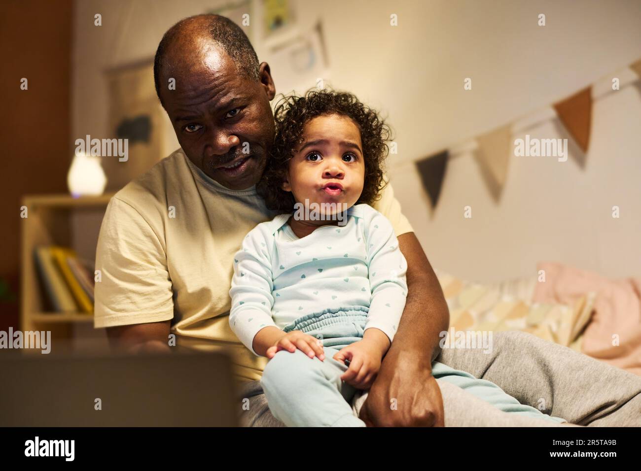 Ein afroamerikanischer Vater, der mit seinem Kind im Schlafzimmer spielte Stockfoto