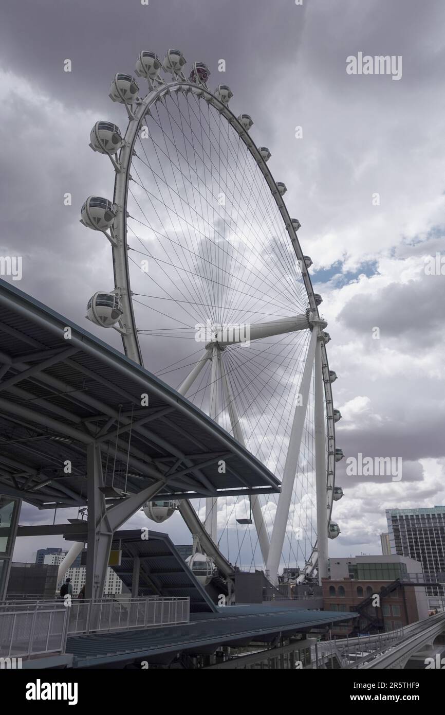 Nahaufnahme eines Rades, das vor einem wolkigen Himmel im Vordergrund einer Stadtlandschaft hängt Stockfoto