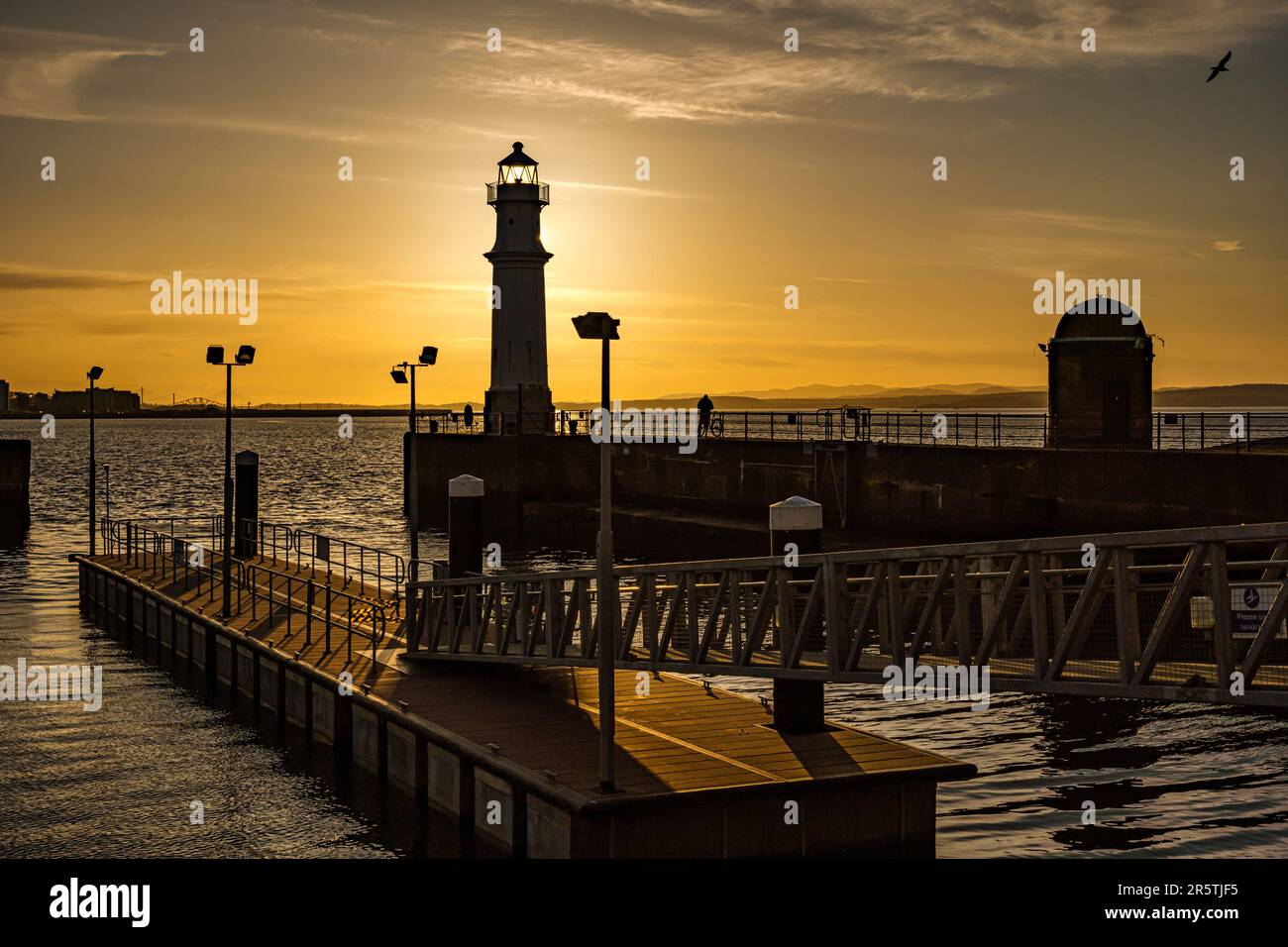 Silhouette des Leuchtturms Newhaven bei farbenfrohem orangefarbenem Sonnenuntergang, Dinburgh, Schottland, Großbritannien Stockfoto