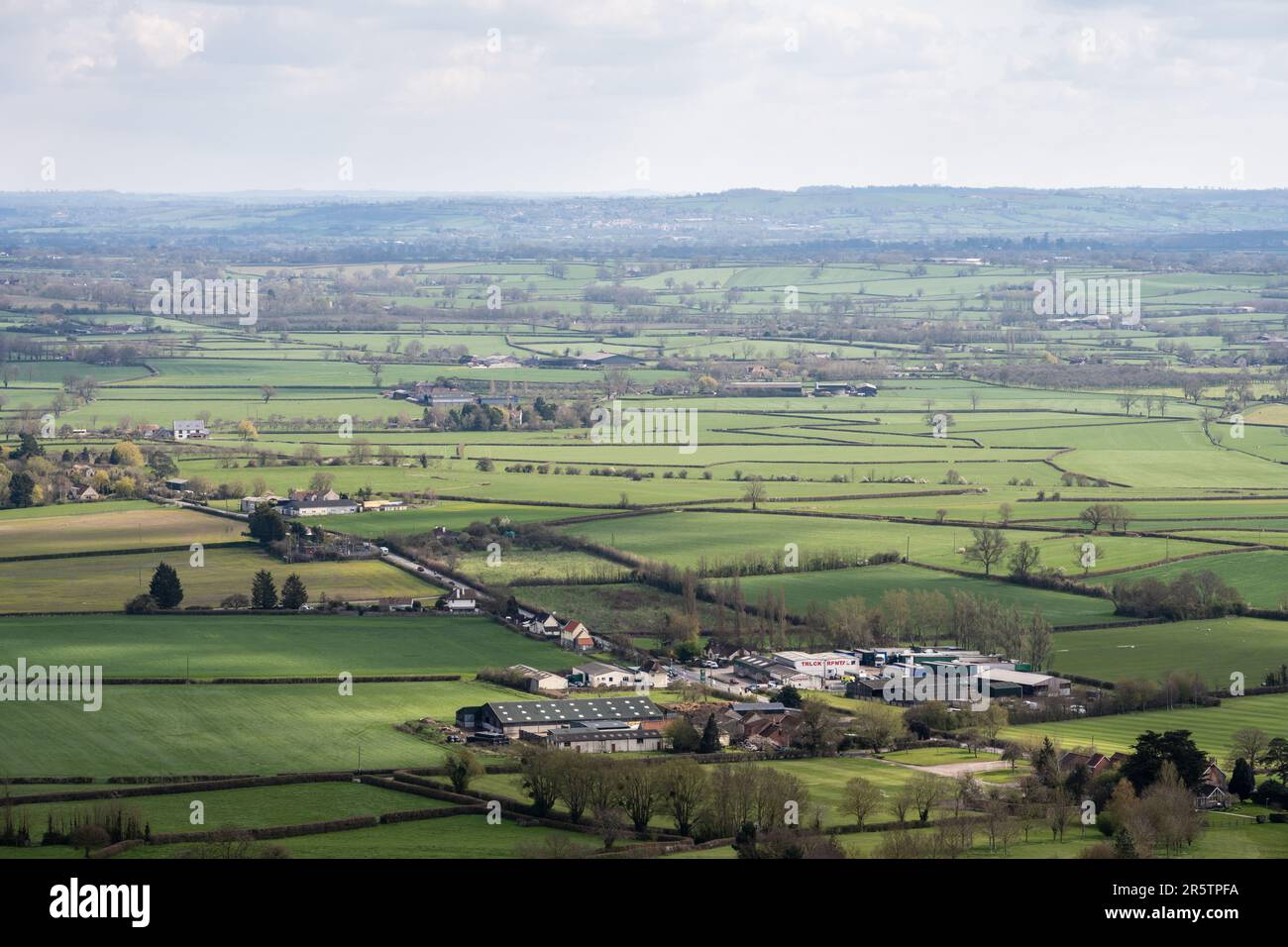 Die niedrige Landschaft der landwirtschaftlichen Felder und der Leichtindustrie umfasst die Somerset-Ebenen südöstlich von Glastonbury Tor, mit Castle Cary auf den Hügeln Stockfoto
