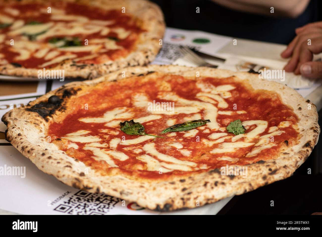 Freunde essen heiße Pizza Margherita mit Tomatensoße, Mozzarella und Basilikum in einer Pizzeria oder einem Restaurant in Italien Stockfoto