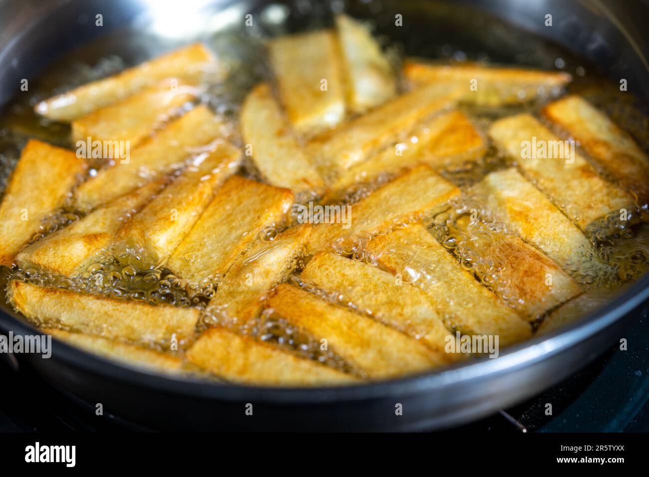 Handgeschnittene Kartoffeln, die in einem Topf braten. Über Schuss Stockfoto