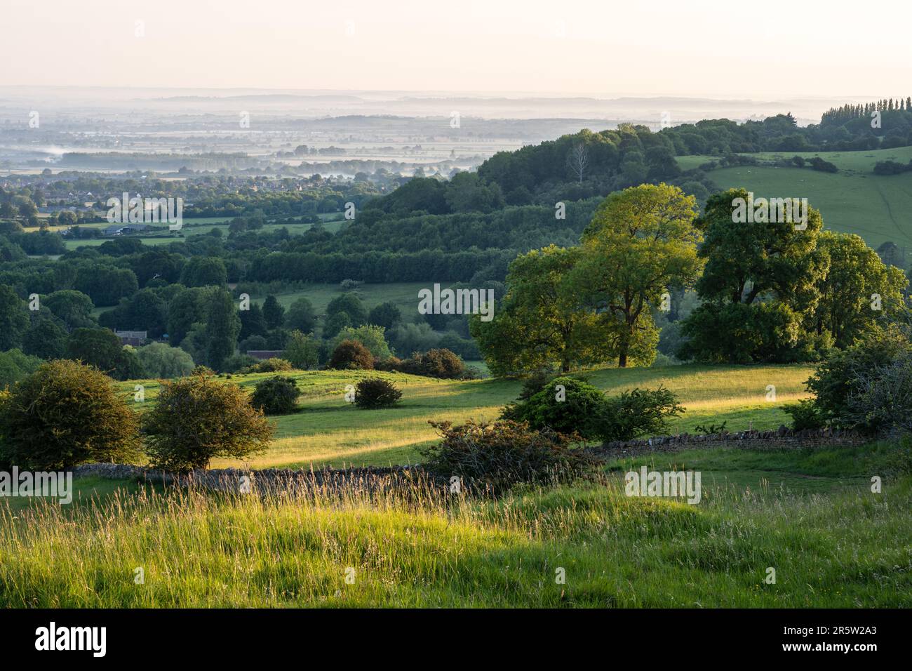 Die steilen Hänge der Cotswold Edge und des flachen Tals von Evesham im Gloucestershire an sind von Ackerland- und Waldflächen durchzogen Stockfoto