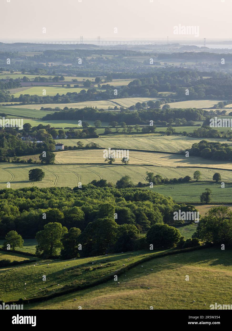 Ackerland-Felder und kleine Wälder bedecken die sanft geschwungene Landschaft des Tals von Berkeley und South Gloucestershire, von der Cotswolds Edge aus gesehen Stockfoto