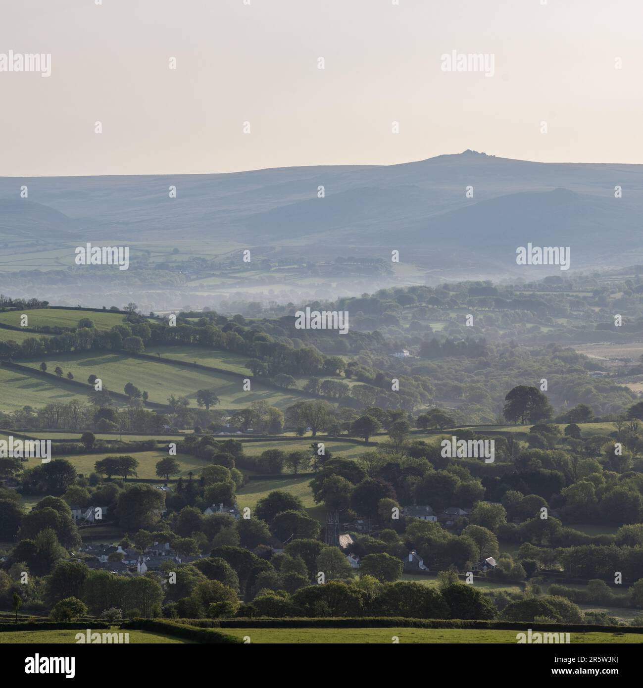 Das Morgenlicht scheint auf dem Ackerland und den Wäldern der Täler Lydford und North Brentor unter den Hügeln und Toren von Dartmoor in West Devon. Stockfoto