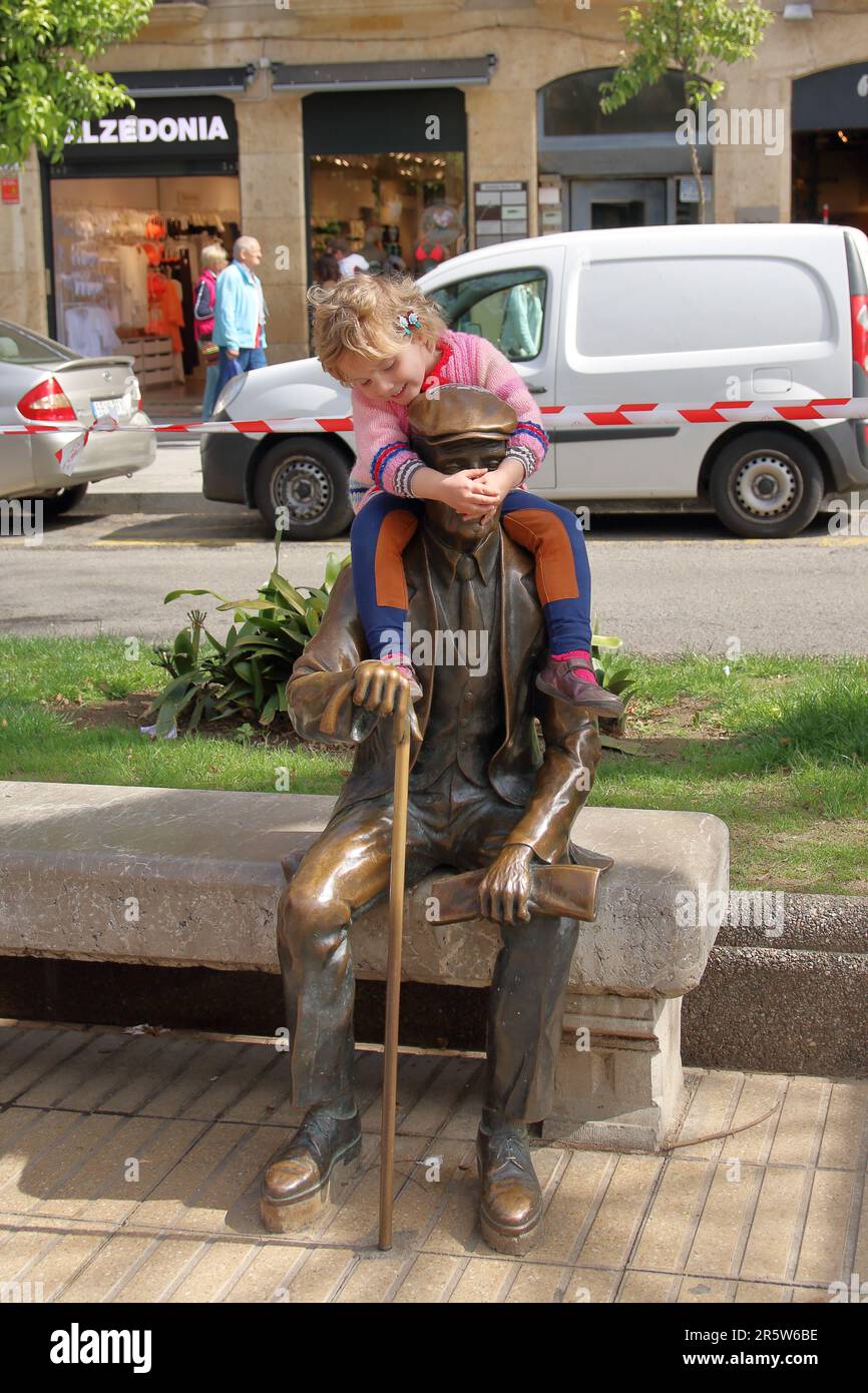 Tarragona, Spanien - 29. April 2016. Ein kleines Mädchen kletterte auf die Schultern des Denkmals des Journalisten Josep Pau Virgili Sanromá und freudig h. Stockfoto