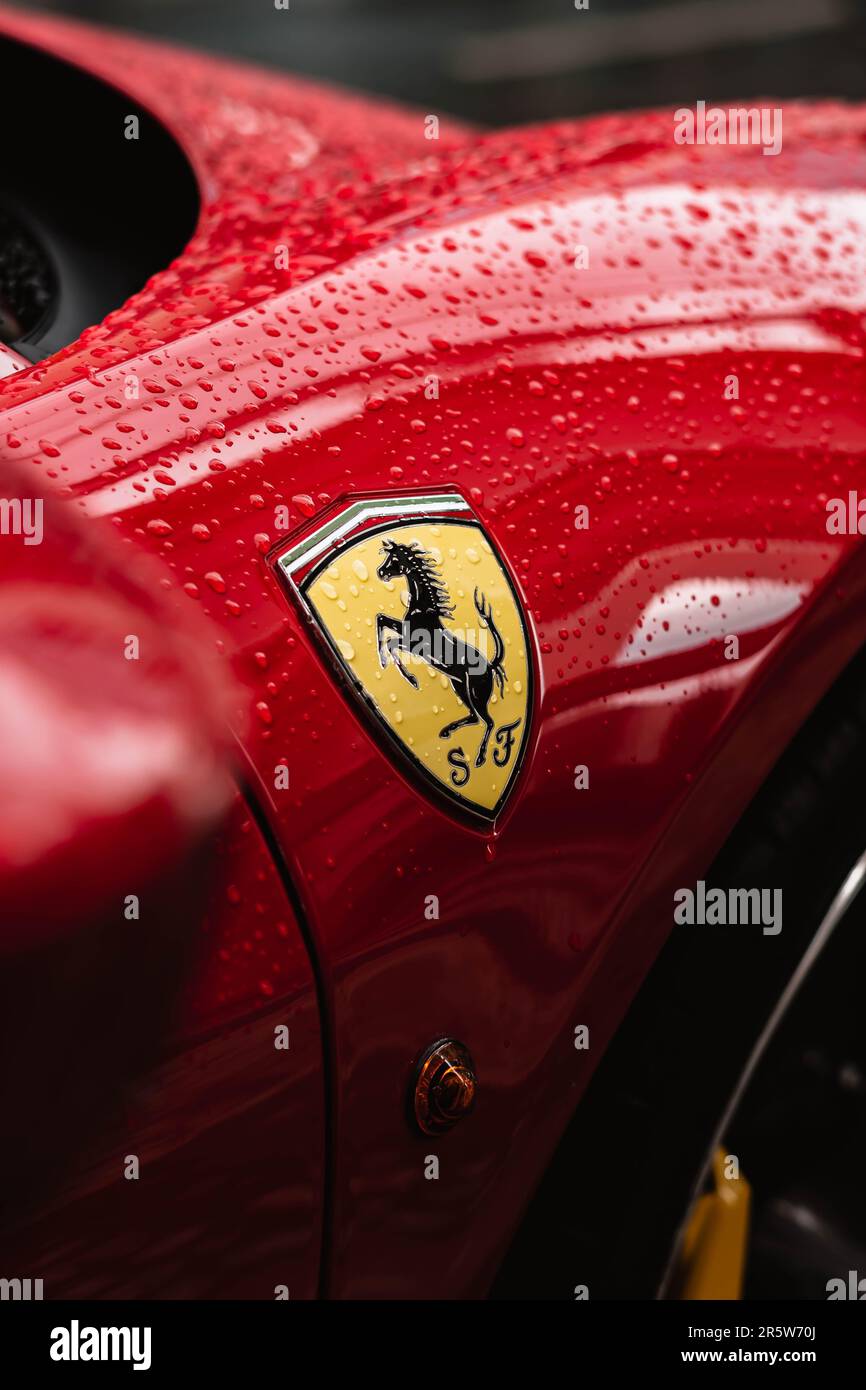 Ein im Regen glitzerndes Emblem am seitlichen Kotflügel des Sportwagens Ferrari 458 Rosso Corsa Stockfoto