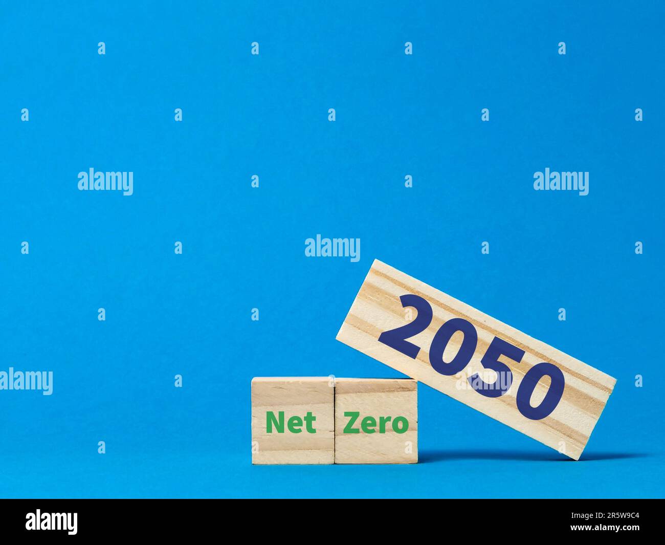 Der Ausdruck net zero 2050 auf Holzblöcken vor blauem Hintergrund. Stockfoto