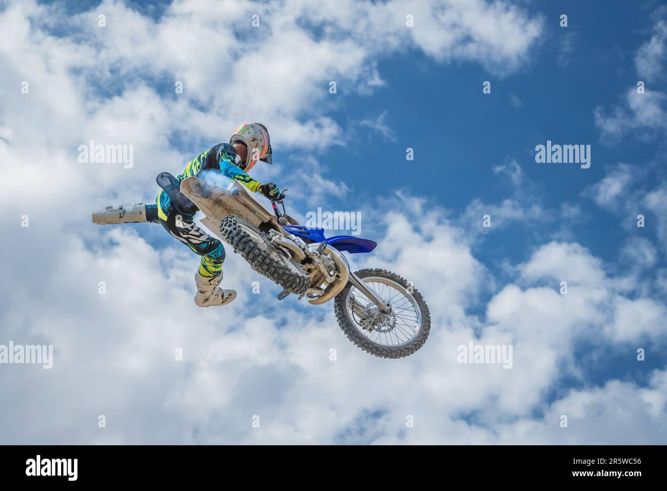 Ein kleiner Winkel eines begeisterten Motocross-Rennfahrers, der sein Motorrad in die Luft springt Stockfoto