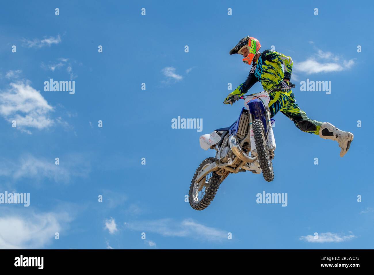 Ein kleiner Winkel eines begeisterten Motocross-Rennfahrers, der sein Motorrad in die Luft springt Stockfoto