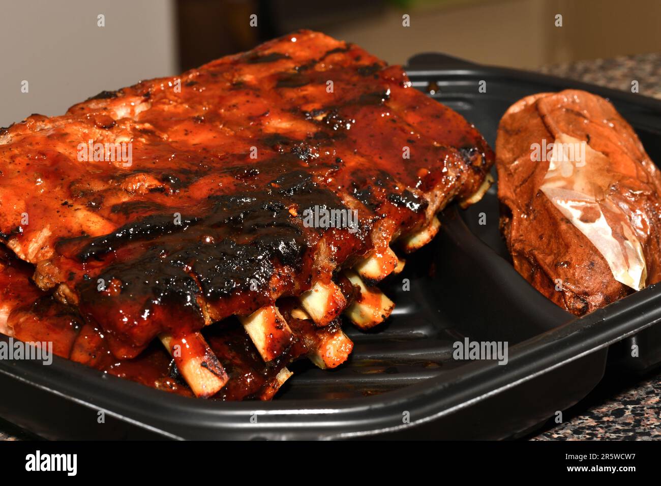 Gegrillte Spareribs in einem Kunststoffbehälter. Grillrippchen. Stockfoto