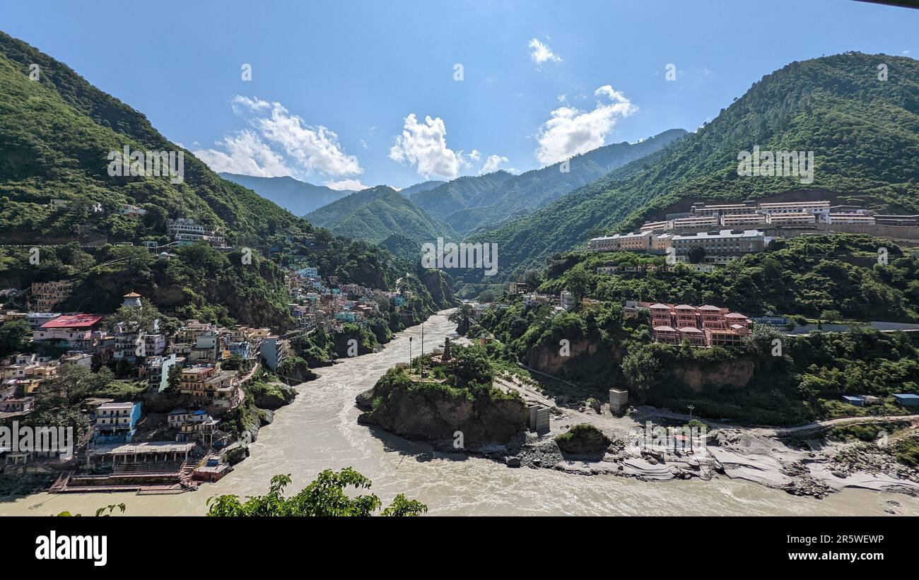 Ein malerischer Blick auf Häuser an den Hängen der grünen Berge am Ufer des Flusses Ganga in Indien Stockfoto