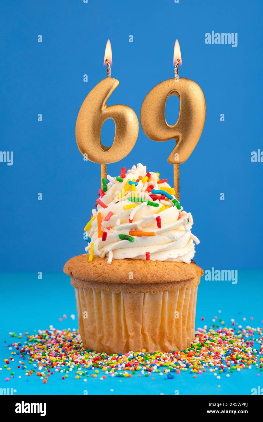Kerze Nummer 69 - Kuchen zum Geburtstag auf blauem Hintergrund Stockfoto