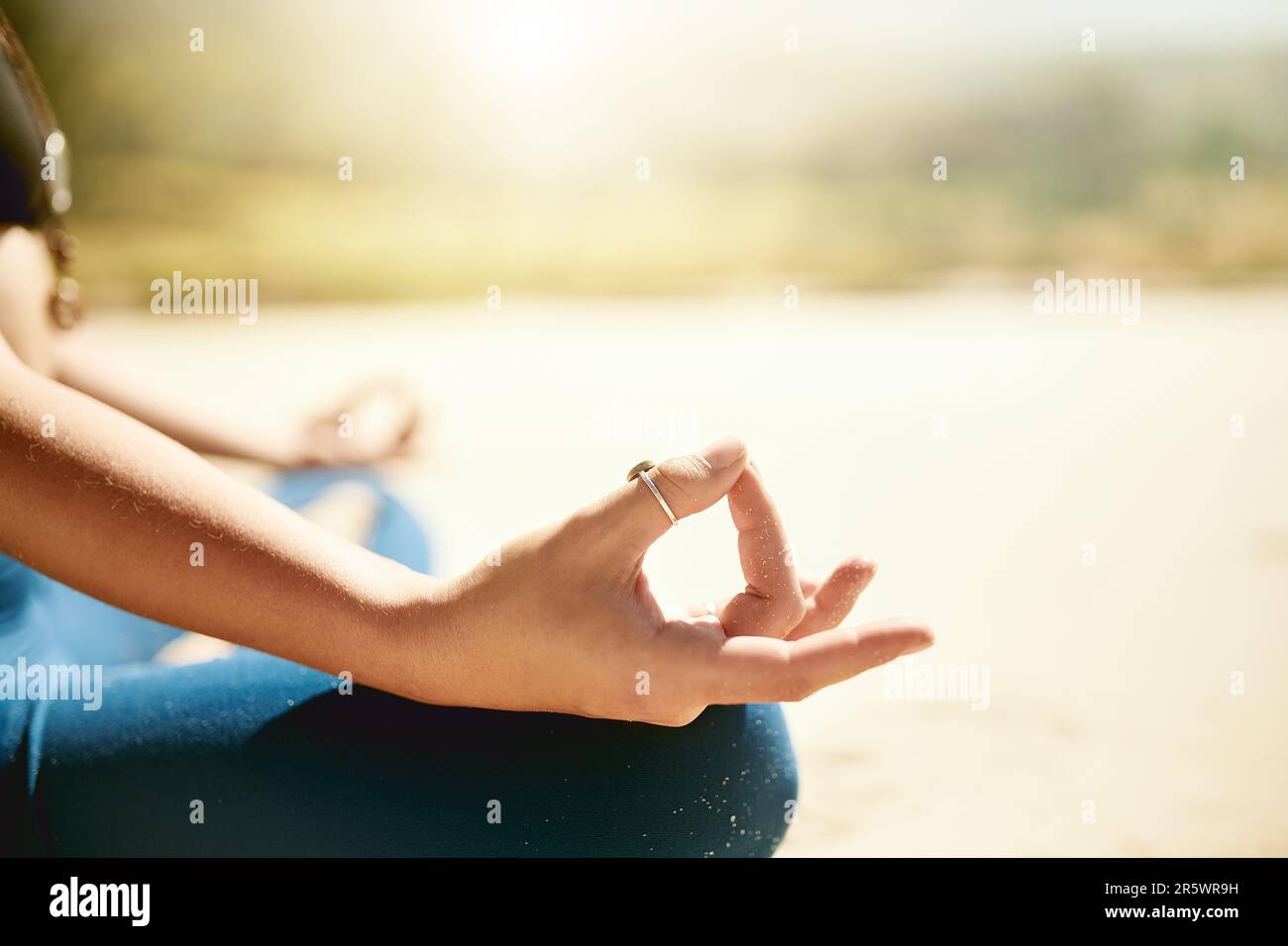 Lass los und befreie dich. Eine unbekannte Frau, die am Strand Yoga praktiziert. Stockfoto