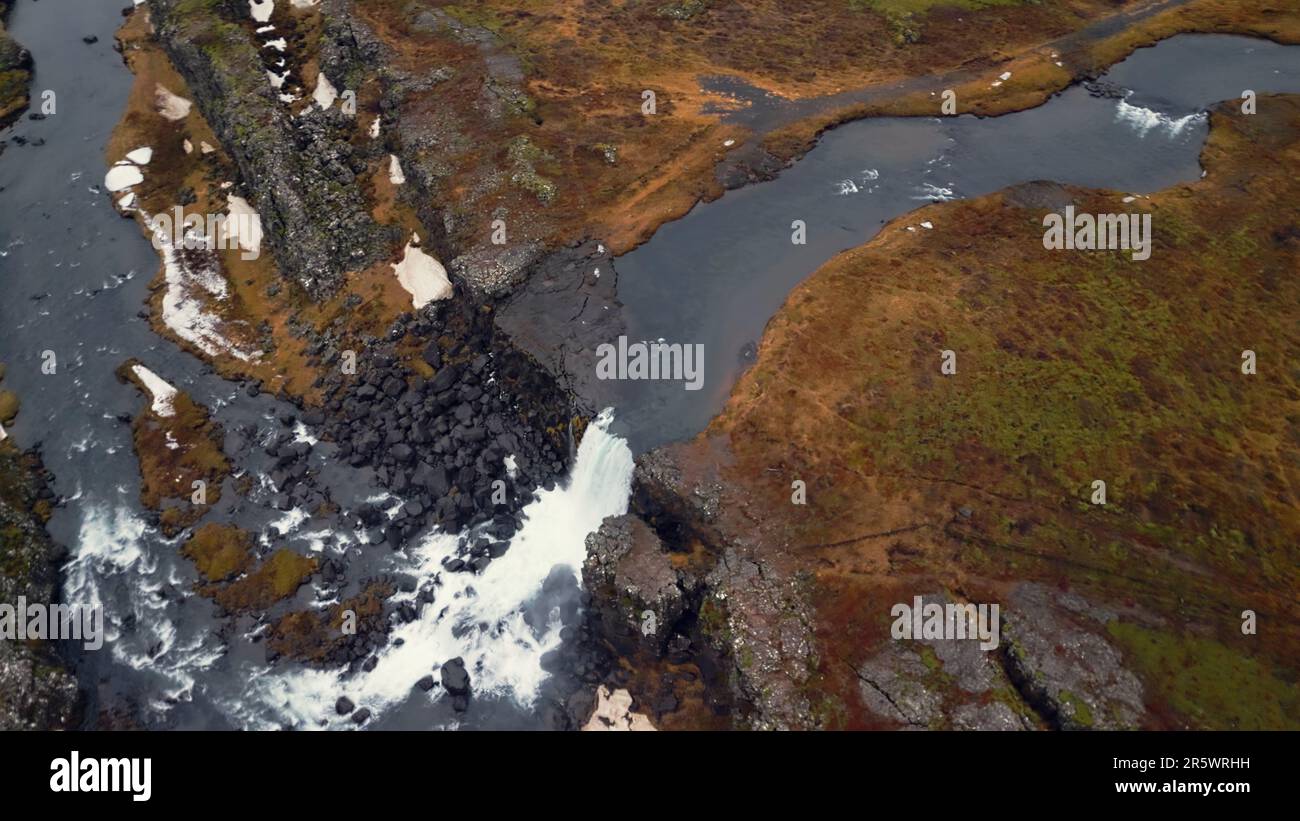 Drohnenaufnahme des nordischen islands Wasserfalls, massiver Wasserstrom, der von den Klippen hinunterfließt und eine wunderschöne Oxarafoss-Kaskade bildet. Isländische Natur und kalter Fluss. Zeitlupe. Stockfoto