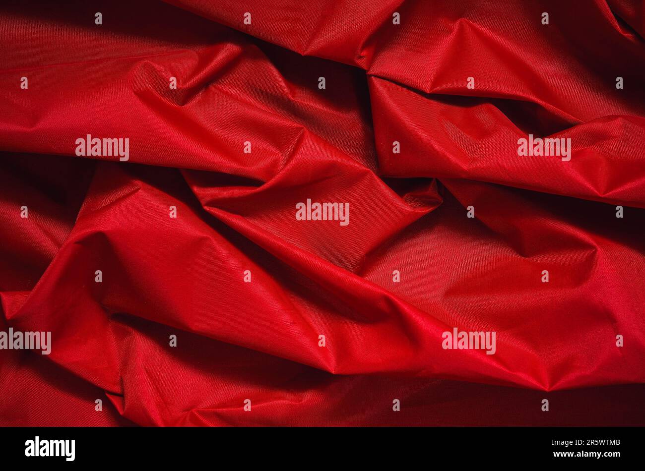 Rotem faltigen Stoff Textur. Nahaufnahme der Textilstruktur werden als Hintergrund verwendet. Stockfoto