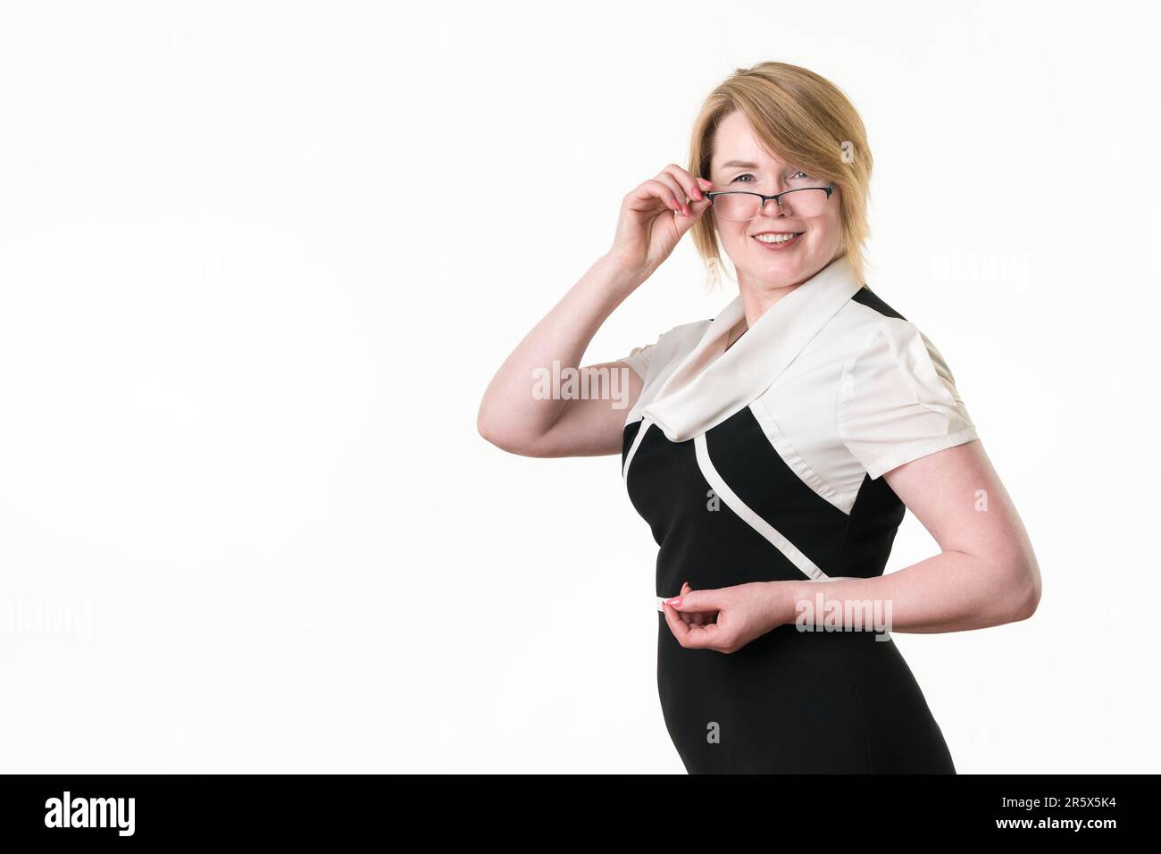Porträt einer weiblichen erwachsenen Geschäftsfrau mit Brille, die in die Kamera schaut und ihre Brille senkt. Attraktive Geschäftsfrau, 49 Jahre alt, Optimis Stockfoto
