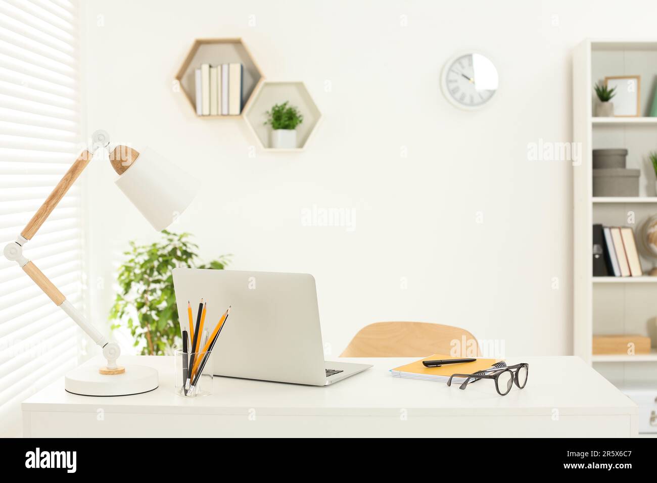 Schöner Arbeitsplatz mit komfortablem Schreibtisch, Laptop und Schreibwaren zu Hause Stockfoto