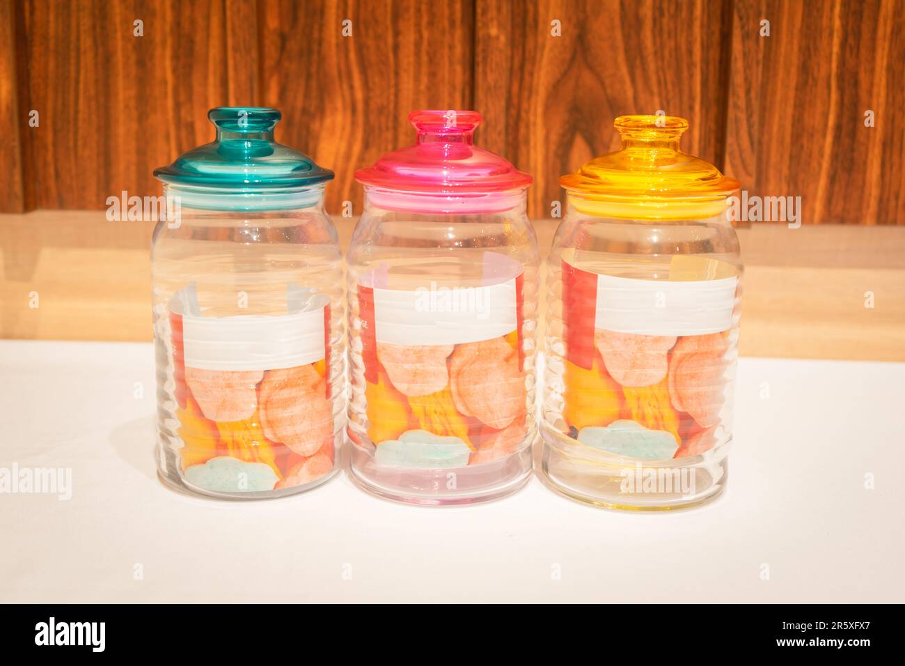 Bunte Glasbecher mit Deckel eignen sich perfekt zum Aufbewahren und Organisieren einer Vielzahl von Gegenständen. Mit ihren leuchtenden Farbtönen und ihrem praktischen Design bieten sie Stockfoto