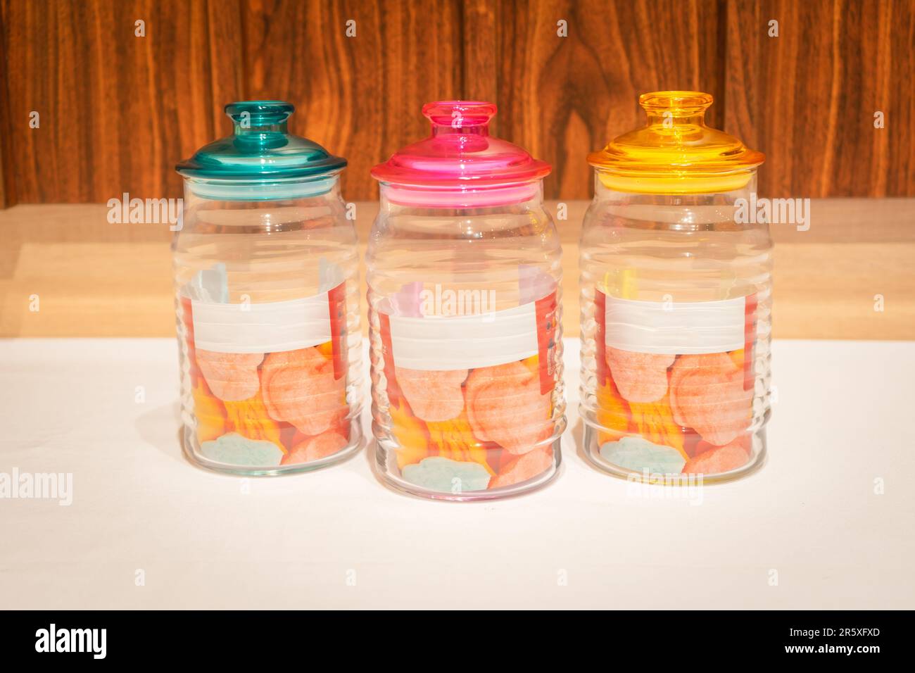 Bunte Glasbecher mit Deckel eignen sich perfekt zum Aufbewahren und Organisieren einer Vielzahl von Gegenständen. Mit ihren leuchtenden Farbtönen und ihrem praktischen Design bieten sie Stockfoto