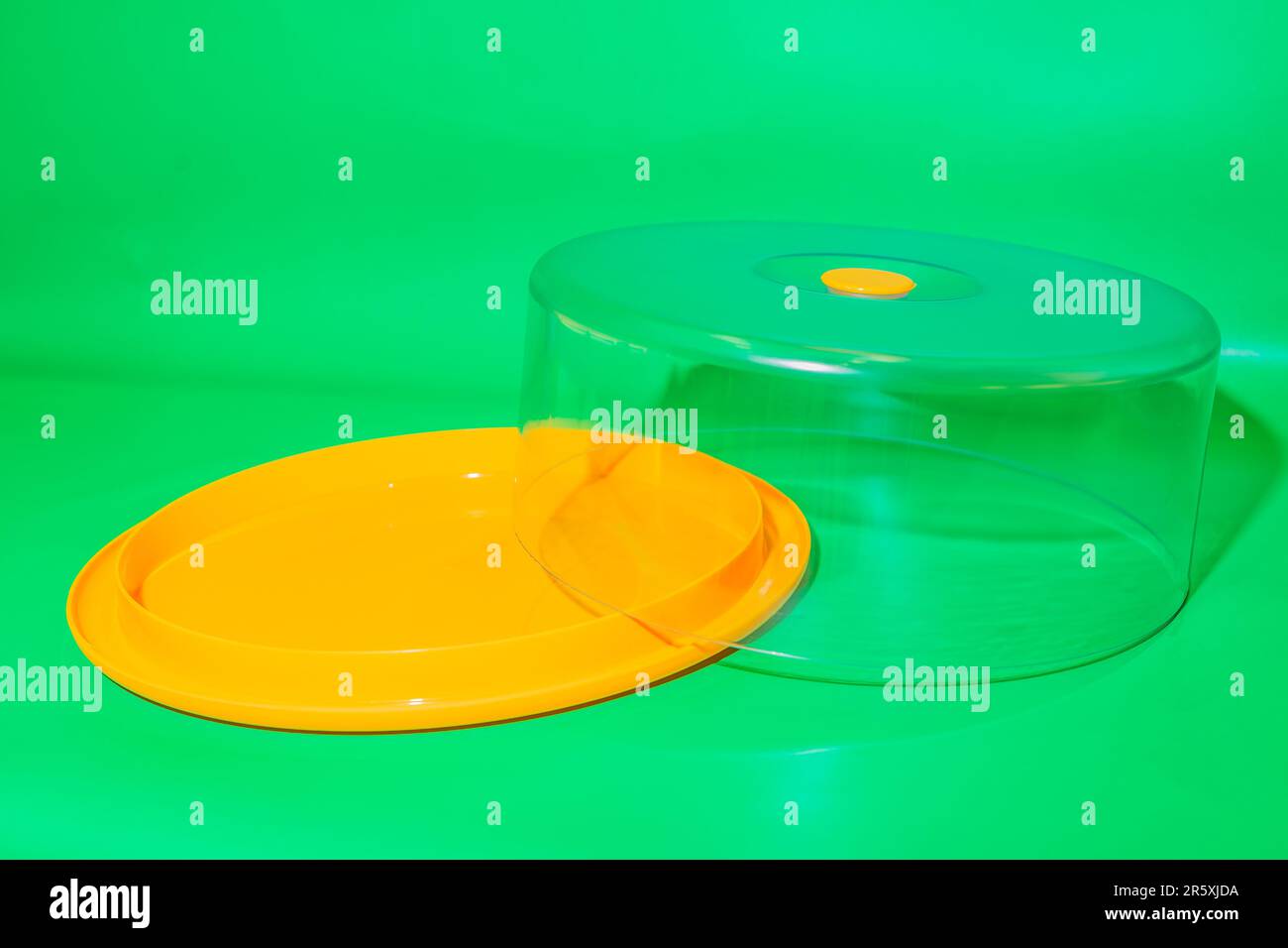 Der gelbe runde Kuchenbehälter mit transparentem Deckel ist eine stilvolle und praktische Aufbewahrungslösung für Ihre köstlichen Kuchen. Stockfoto