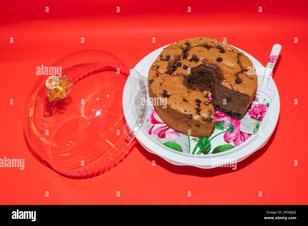 Der runde Kuchenstand aus weißem Keramik mit Blumenmotiv ist ein atemberaubendes Herzstück für Ihre Desserts. Stockfoto