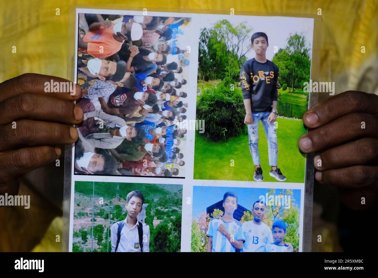 Rohingya refugee Muhammed Rashid holds photos of his son, Saiful Islam, at the Nayapara refugee camp in the Cox's Bazar district of Bangladesh, on March 7, 2023. Rashid believes he sees Saiful in the photo of a group of Rohingya refugees in Indonesia he found online, at top left. (AP Photo/Mahmud Hossain Opu) Stockfoto
