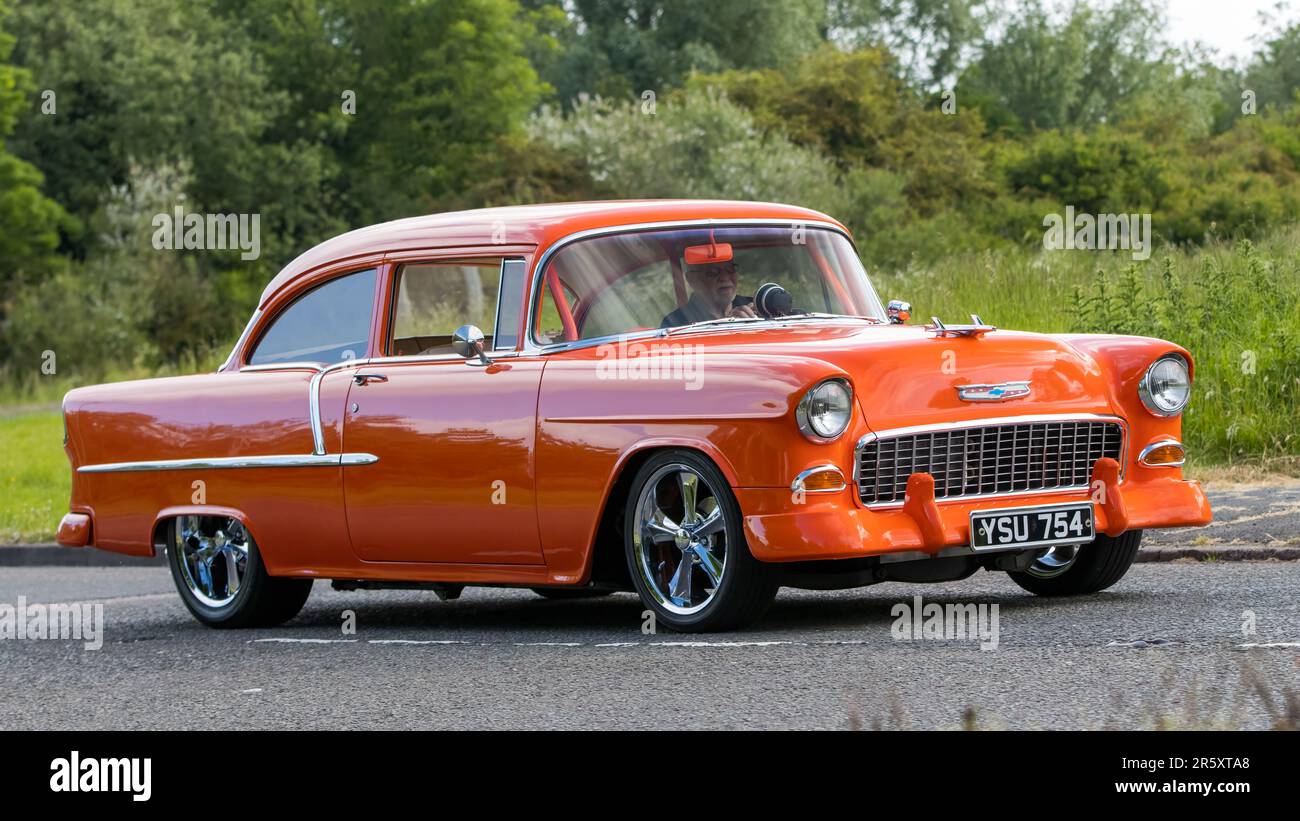 Stony Stratford, Großbritannien - Juni 4. 2023: 1955 orangefarbenes CHEVROLET GMC 210-Oldtimer, das auf einer englischen Landstraße fährt. Stockfoto