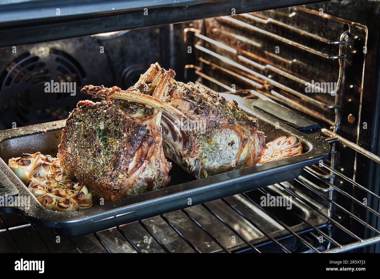 Lammrippchen mit Knoblauch und Sauce, die im Ofen gebacken wurden Stockfoto