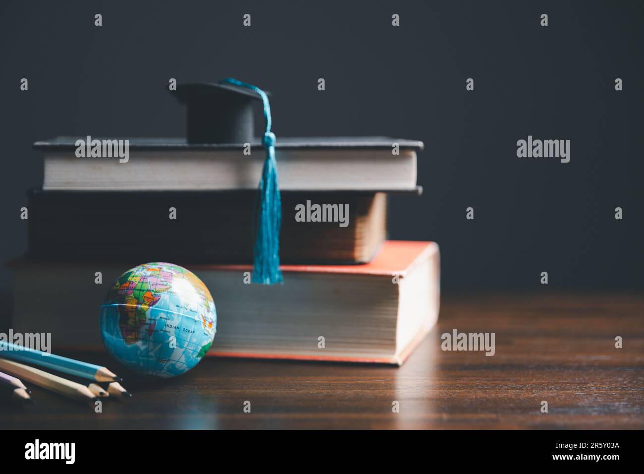 Graduierungskappe mit Erdkugel. Konzept von globalem Wirtschaftsstudium, Auslandsausbildung, Schulanfang. Bildung in der globalen Welt, Studium im Ausland Stockfoto