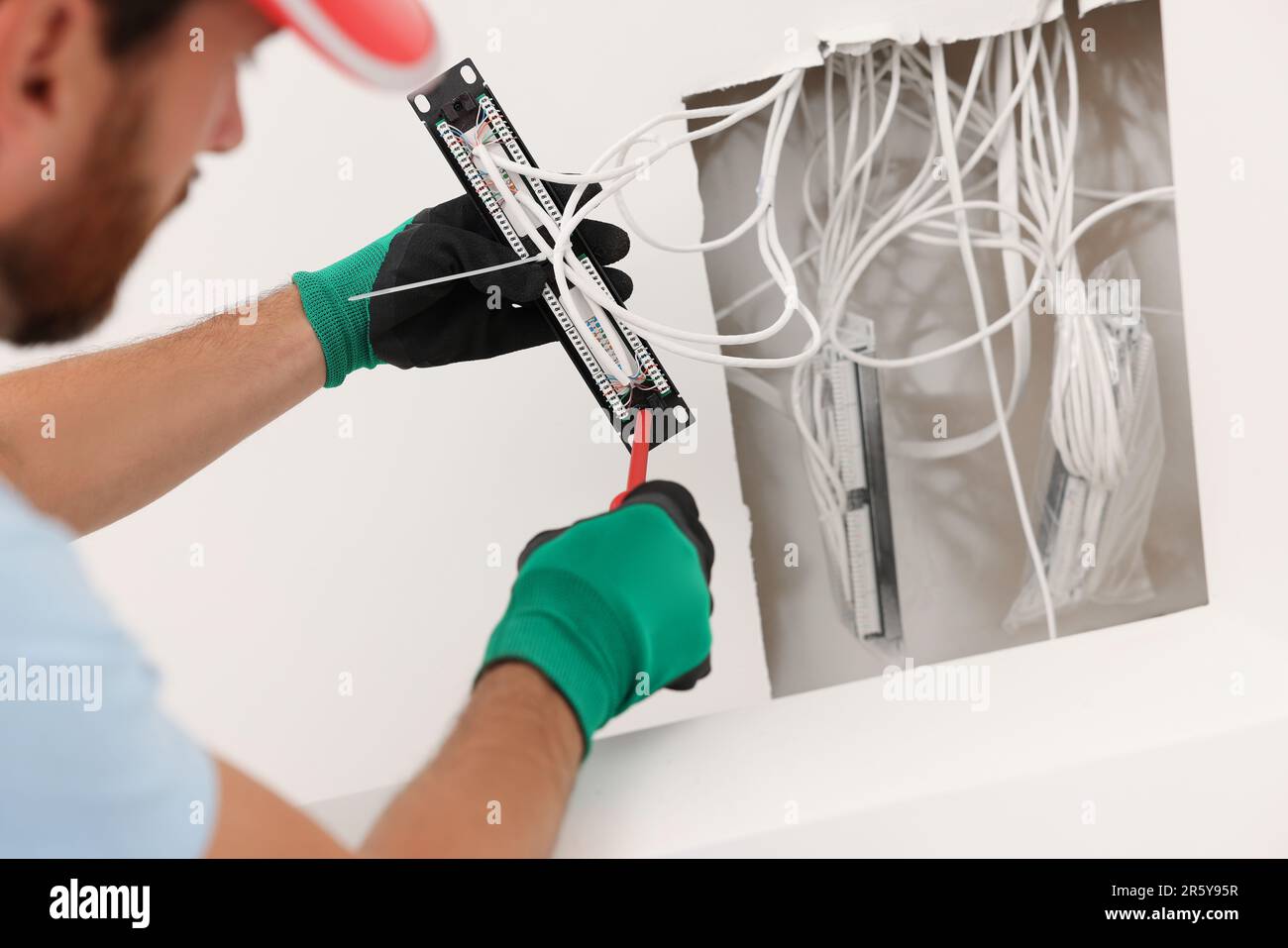 Elektriker mit schraubendrehbarem Patchpanel im Innenbereich Stockfoto