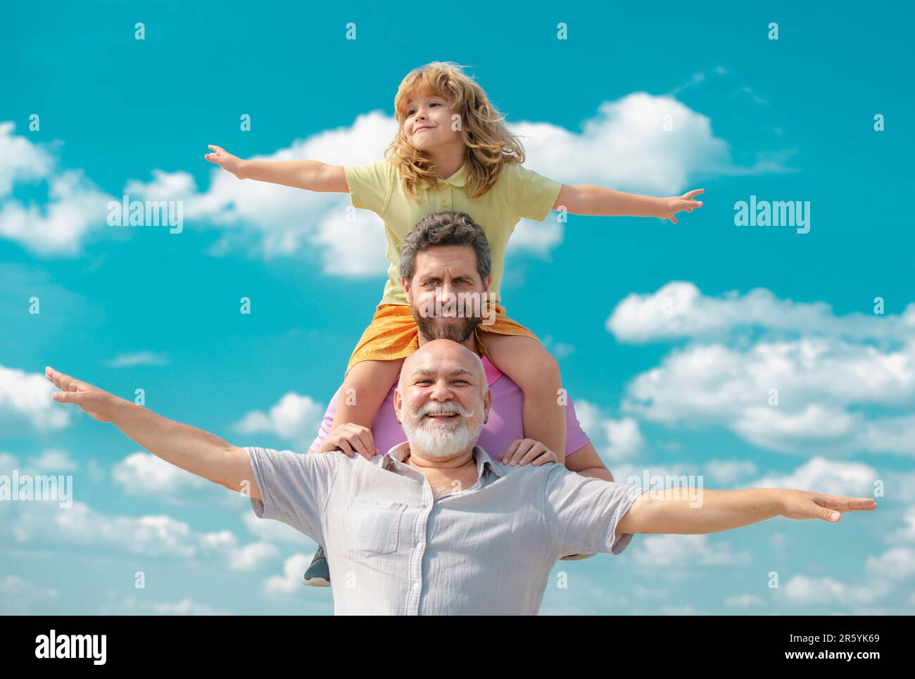 Generationenfamil. Vater, Sohn und Großvater glücklich Multi-Genration Familie mit Heben der Hände oder offene Arme fliegen am Himmel. Stockfoto