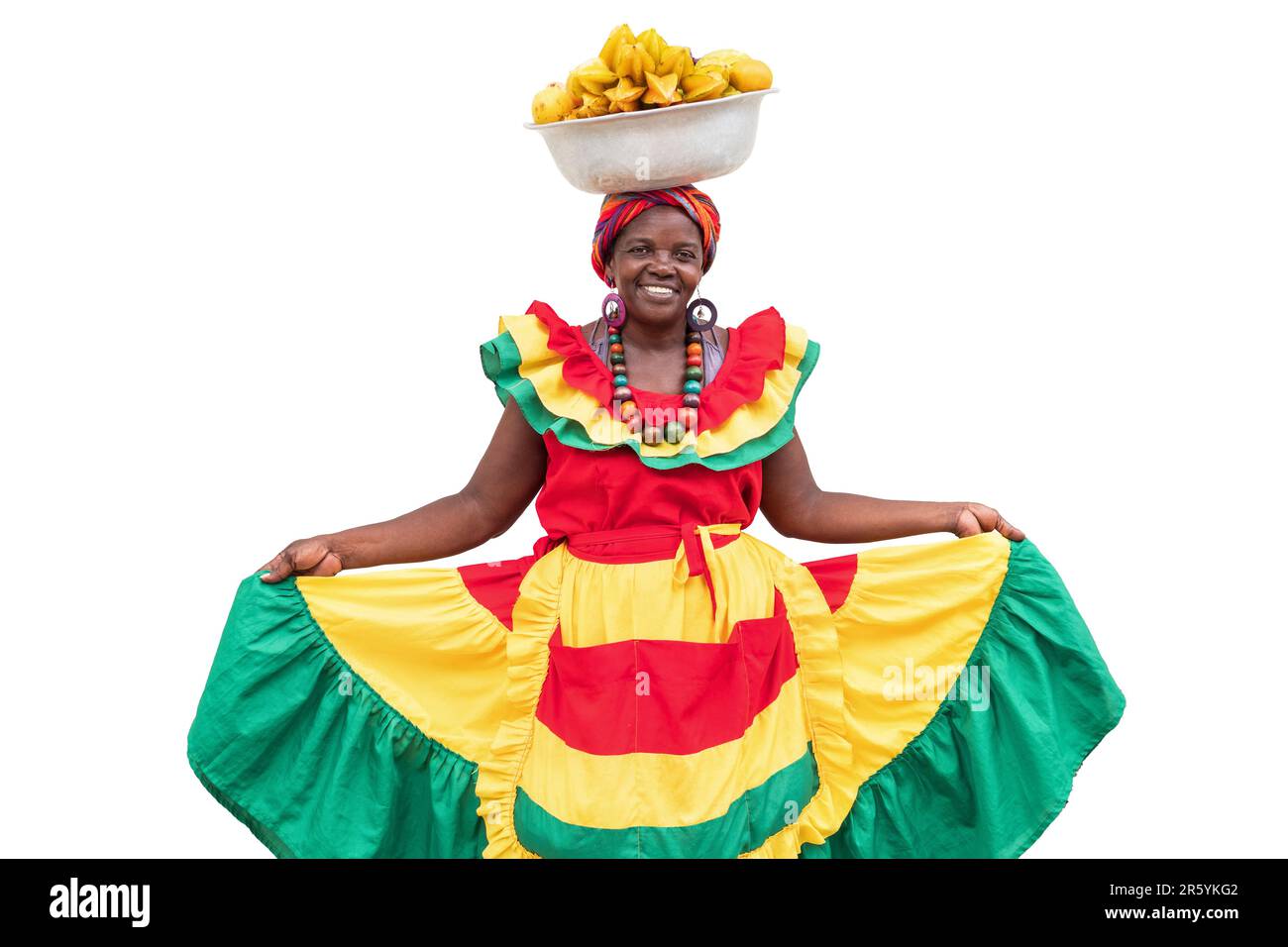 Fröhlich lächelnder Palenquera-Straßenverkäufer mit frischem Obst aus Cartagena, Kolumbien, isoliert auf weißem Hintergrund. Afro-kolumbianische Frau in traditioneller Kleidung. Stockfoto