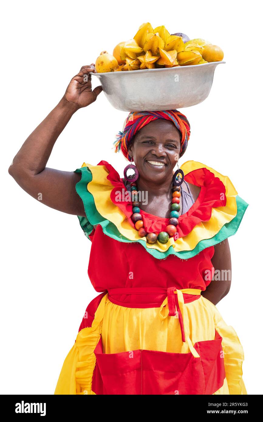Fröhlich lächelnder Palenquera-Straßenverkäufer mit frischem Obst aus Cartagena, Kolumbien, isoliert auf weißem Hintergrund. Afro-kolumbianische Frau in traditioneller Kleidung. Stockfoto