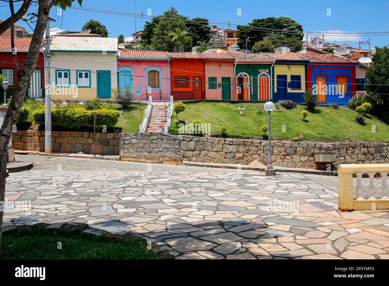 Eine Reihe farbenfroher Fassaden und Grünflächen mit blauem Himmel in der historischen Stadt São Luíz do Paraitinga, Brasilien Stockfoto