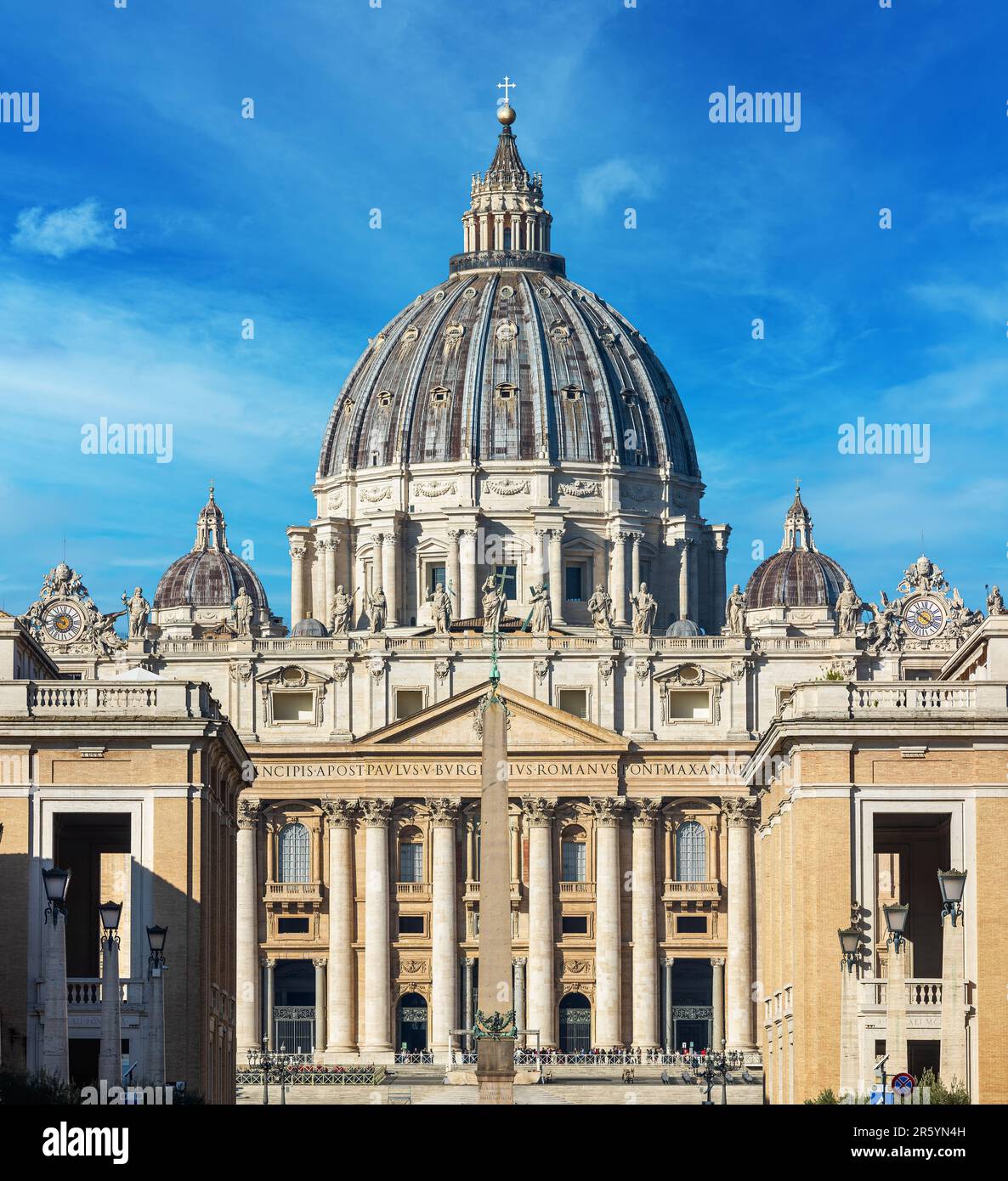 Fassade der berühmten päpstlichen Basilika (auch bekannt als Petersdom) unter blauem Himmel im Vatikan. Stockfoto