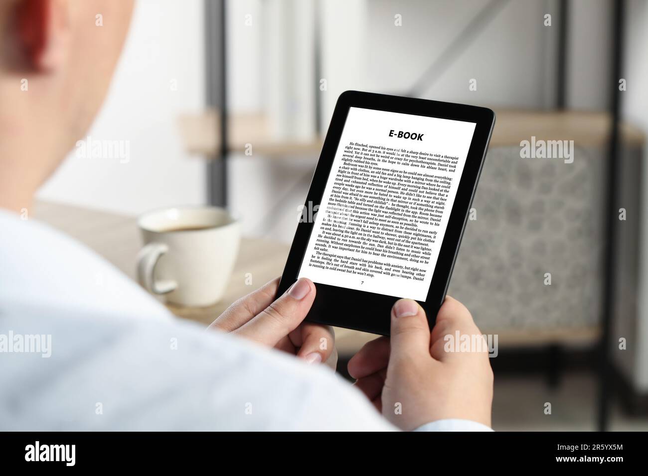 Mann liest Buch im elektronischen Format mit E-Reader, Nahaufnahme Stockfoto