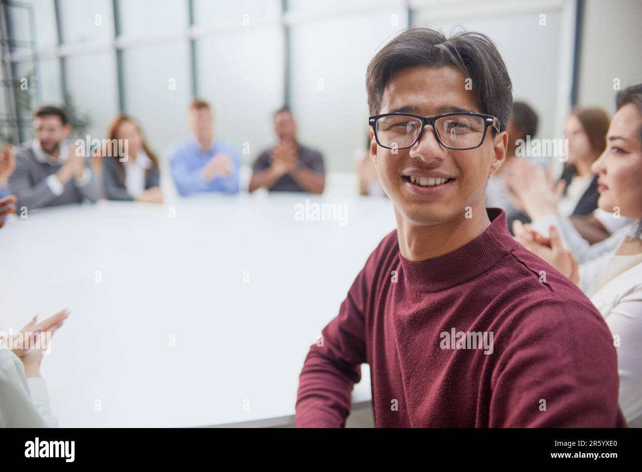 Junger, gutaussehender Geschäftsmann mit Brille, der vor der Kamera posiert Stockfoto