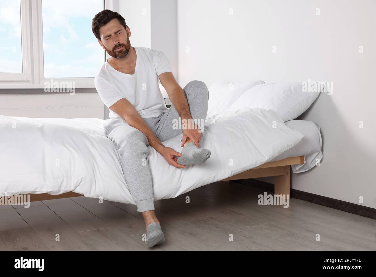 Mann mit Beinschmerzen zu Hause im Bett Stockfotografie - Alamy