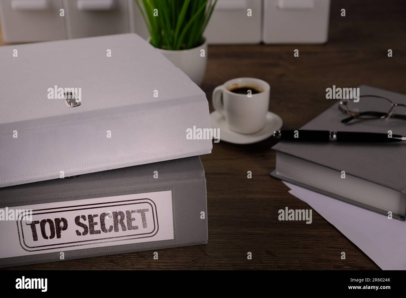 Ordner mit Dokumenten und Top-Secret-Stempel auf Holztisch, Nahaufnahme Stockfoto