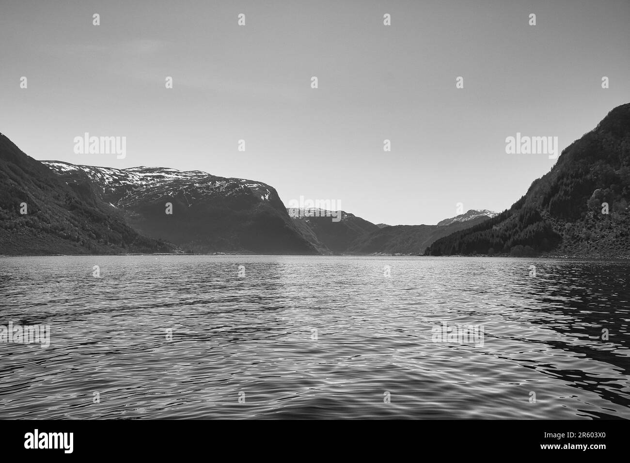 Fjord mit Blick auf Berge und Fjordlandschaft in Norwegen in Schwarz und Weiß. Landschaftsaufnahmen mit sonniger Aussicht aus dem Norden Skandinaviens Stockfoto