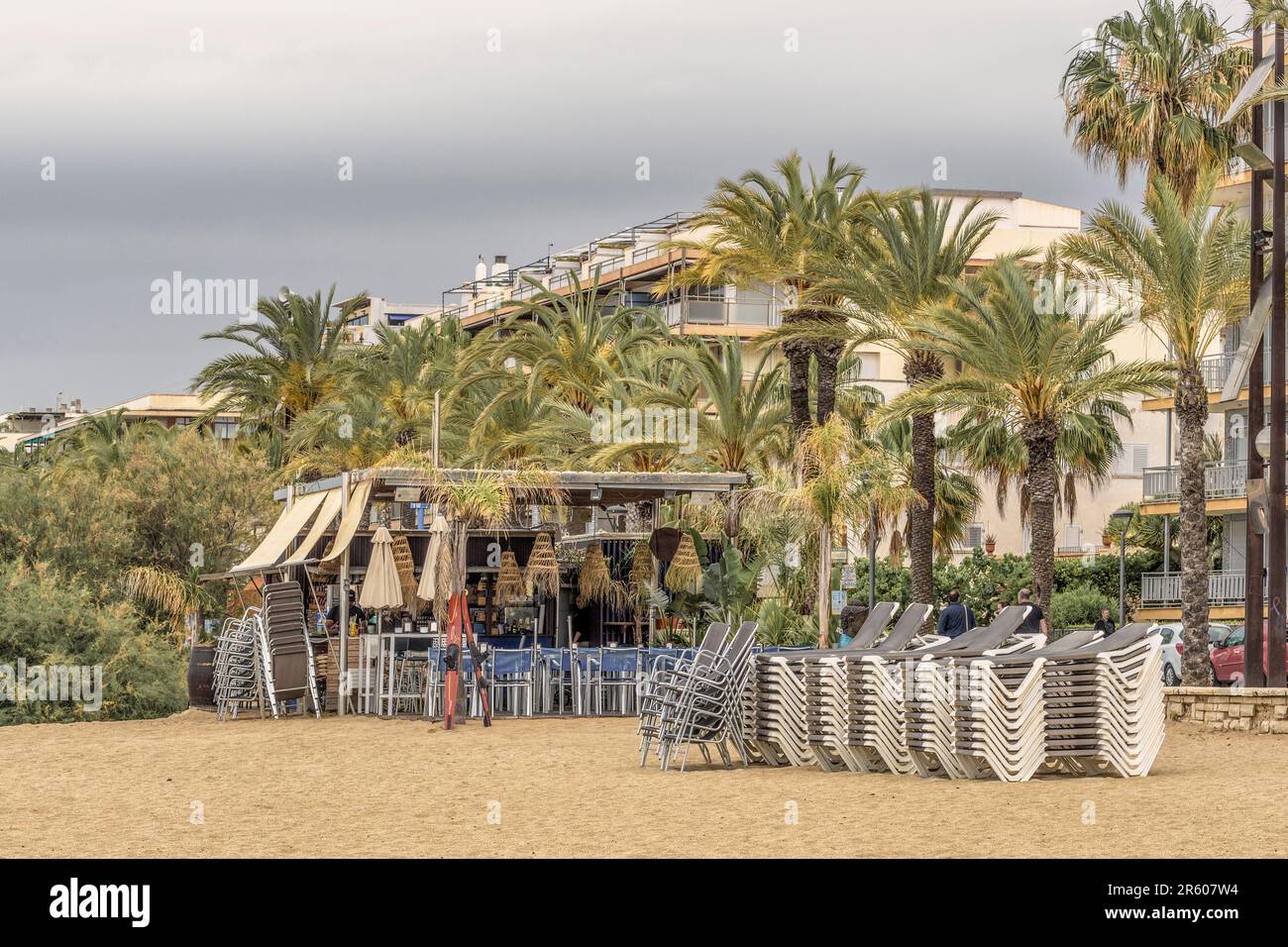 Terrasse einer Bar am Poniente Strand mit Dach, Lichtern, Palmen, Stühlen und Tischen in der Stadt Salou, Costa Daurada, Tarragona, Katalonien. Stockfoto