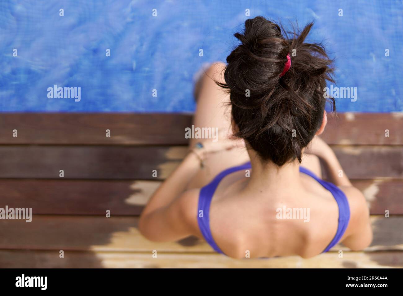 Luftaufnahme einer schlanken Frau, die im Pool sitzt Stockfoto