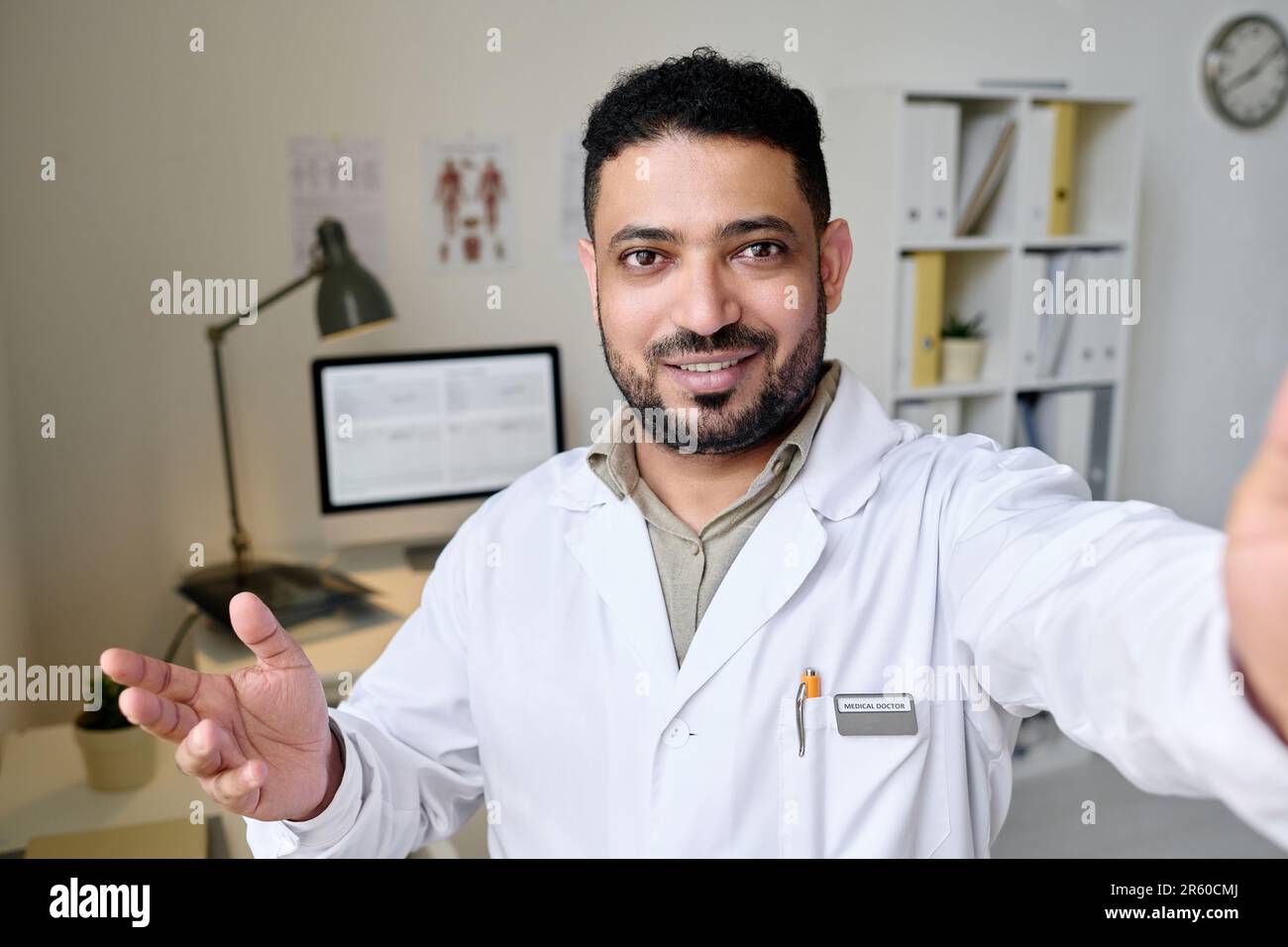 Professioneller Arzt schaut in die Kamera, während er online mit dem Patienten spricht Stockfoto