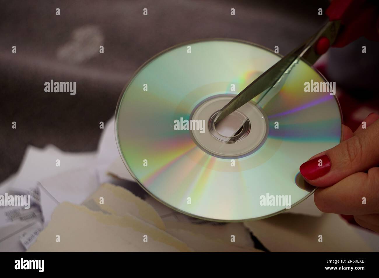 Frau schneidet alte CDs mit einer Schere zu Hause aus nächster Nähe Stockfoto